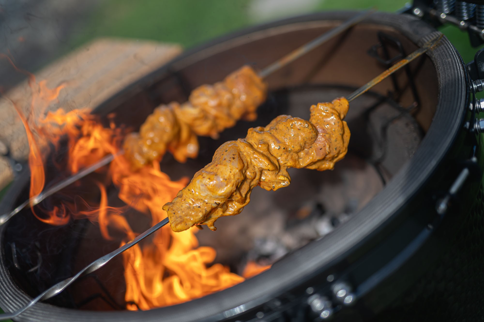 Tandoori kura na ražni nad plameňmi — dramatický záber