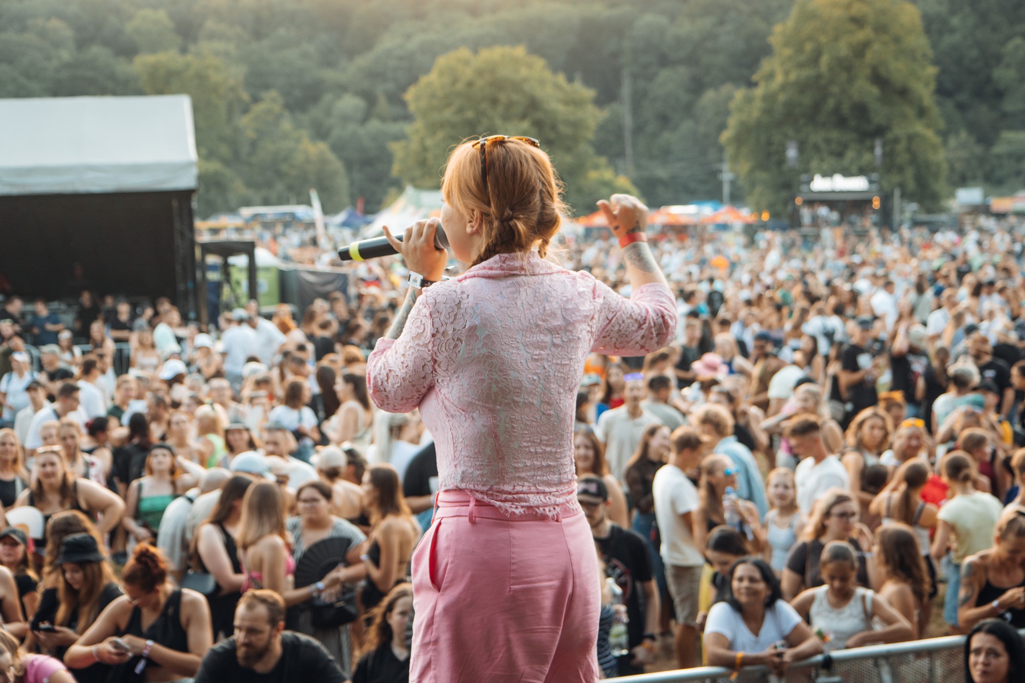 Evelina Švrčková zezadu s mikrofonem před davem na Hrady CZ