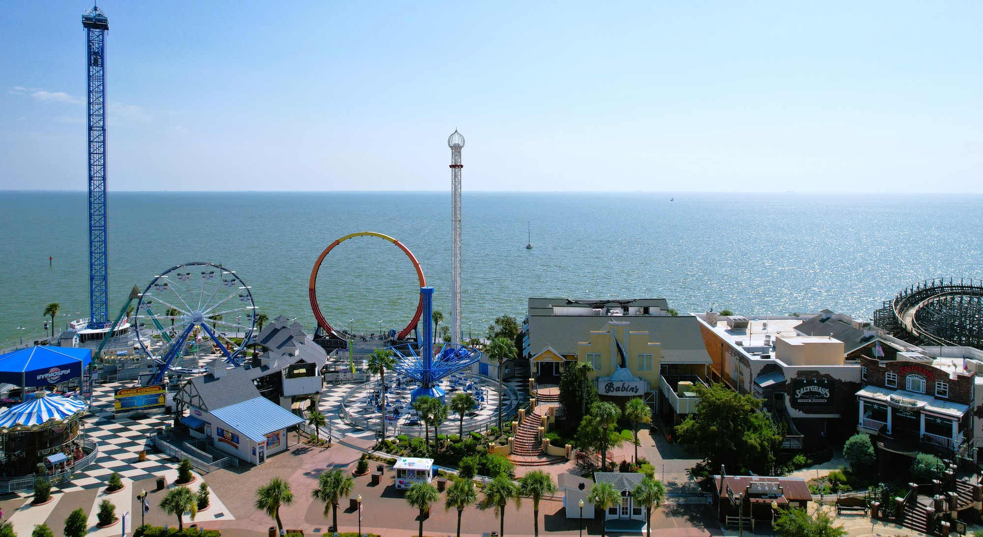 Aerial drone view of a coastal amusement park and pier