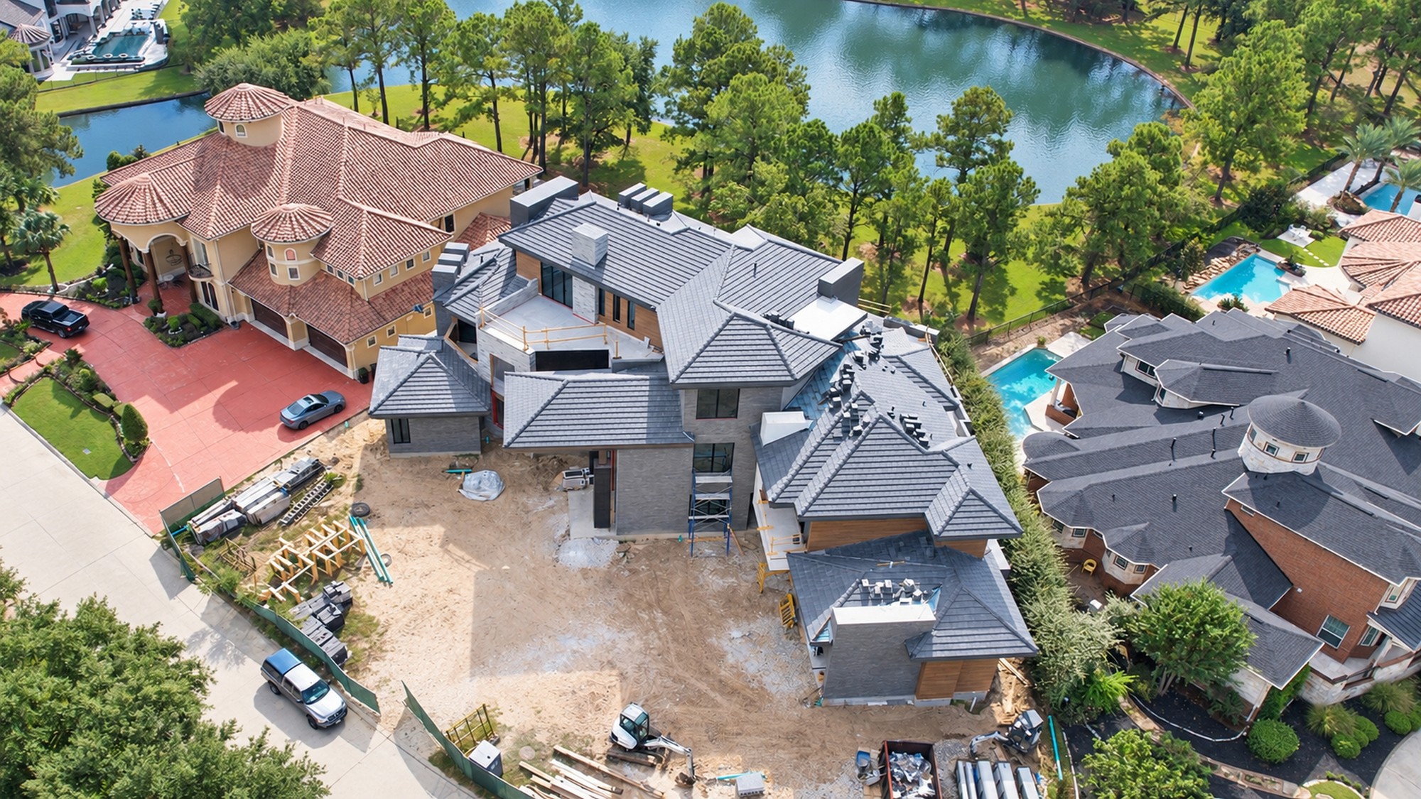 Aerial drone photo of a luxury lakeside home under construction in a Houston-area gated community
