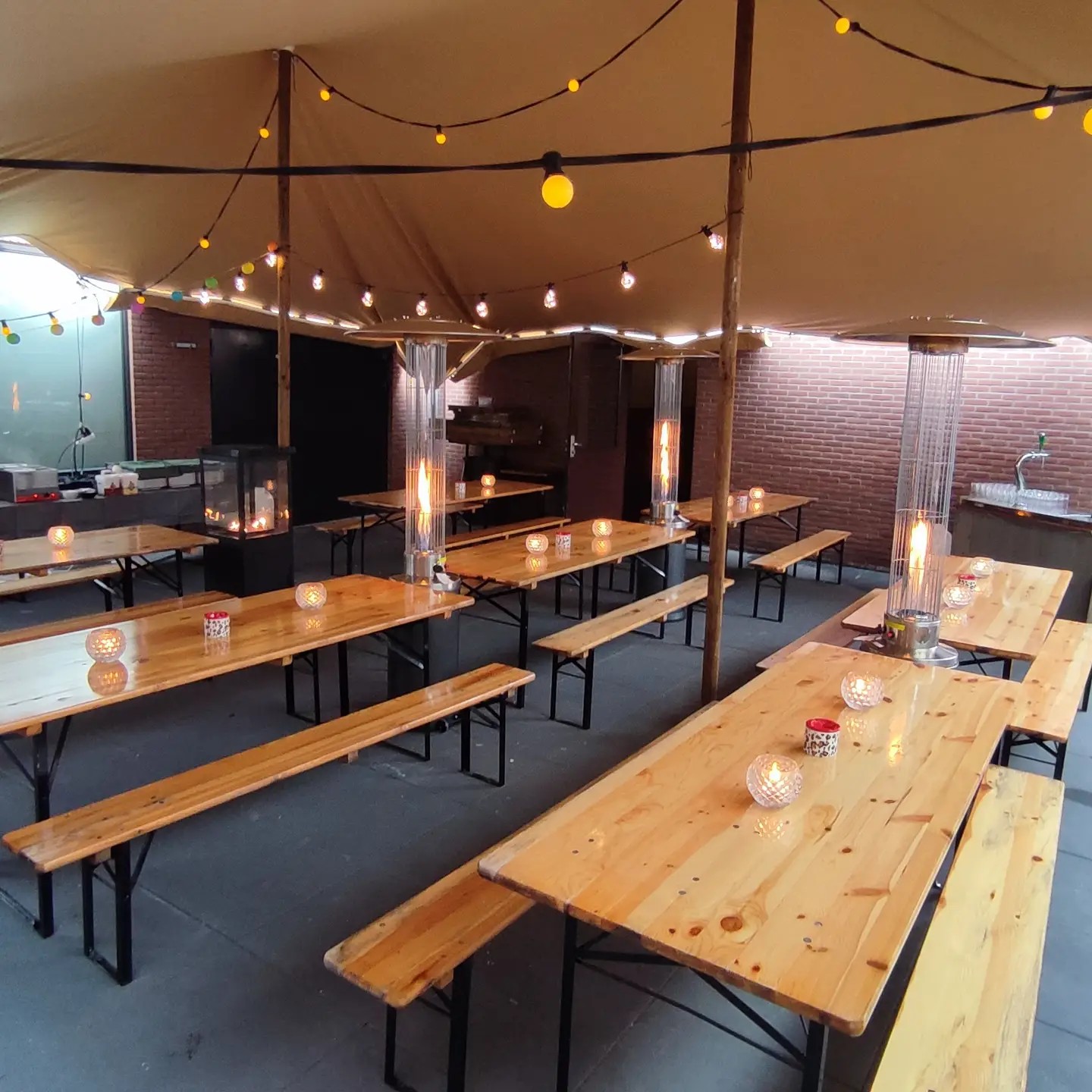 Lange tafels en sfeerverlichting in de stretchtent
