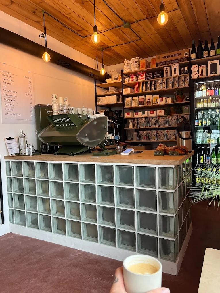 Zelený espresso stroj a dřevěný pult uvnitř kiosku