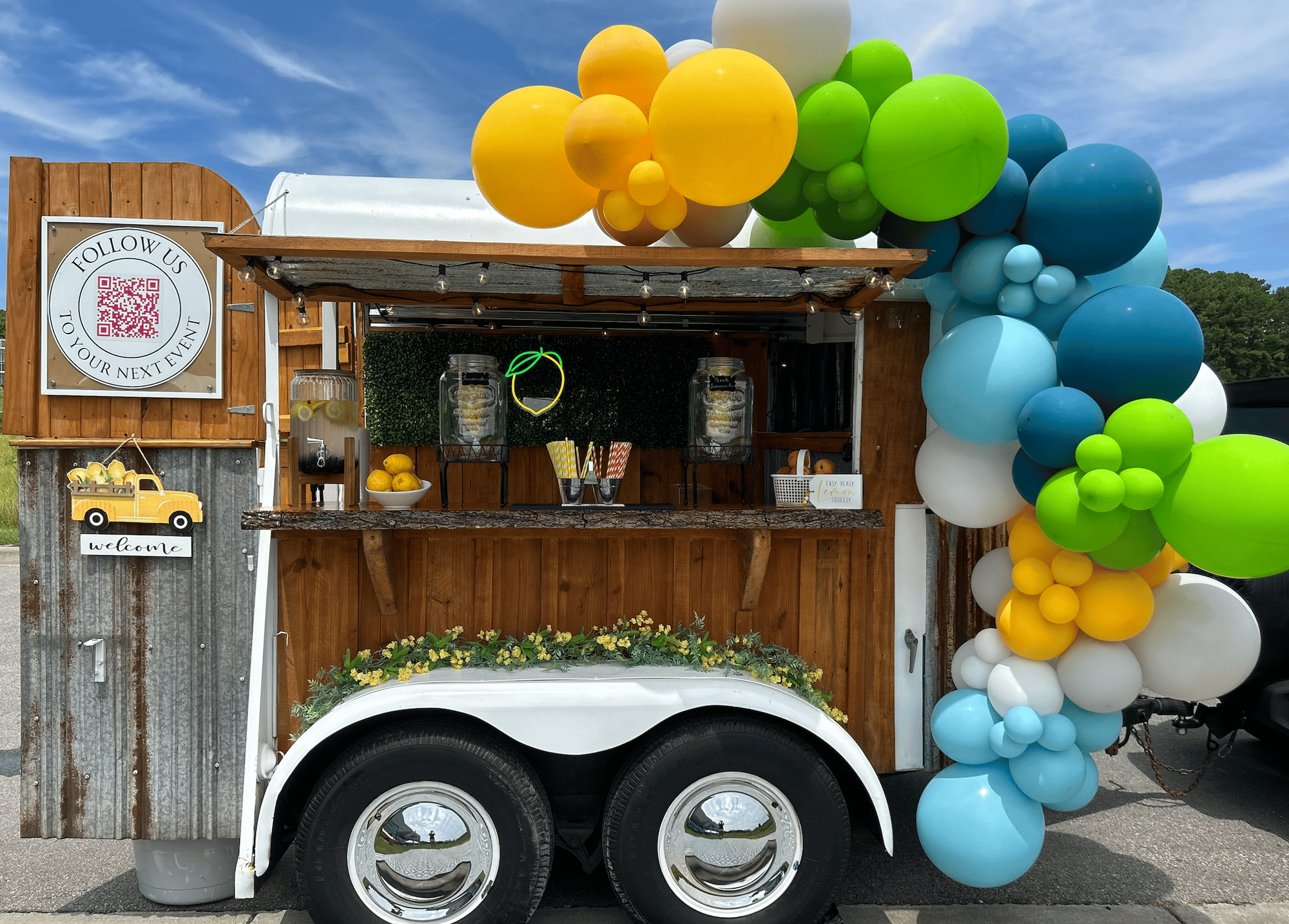 The Hitching Post trailer fully styled with custom balloon garland and branded décor for a corporate event