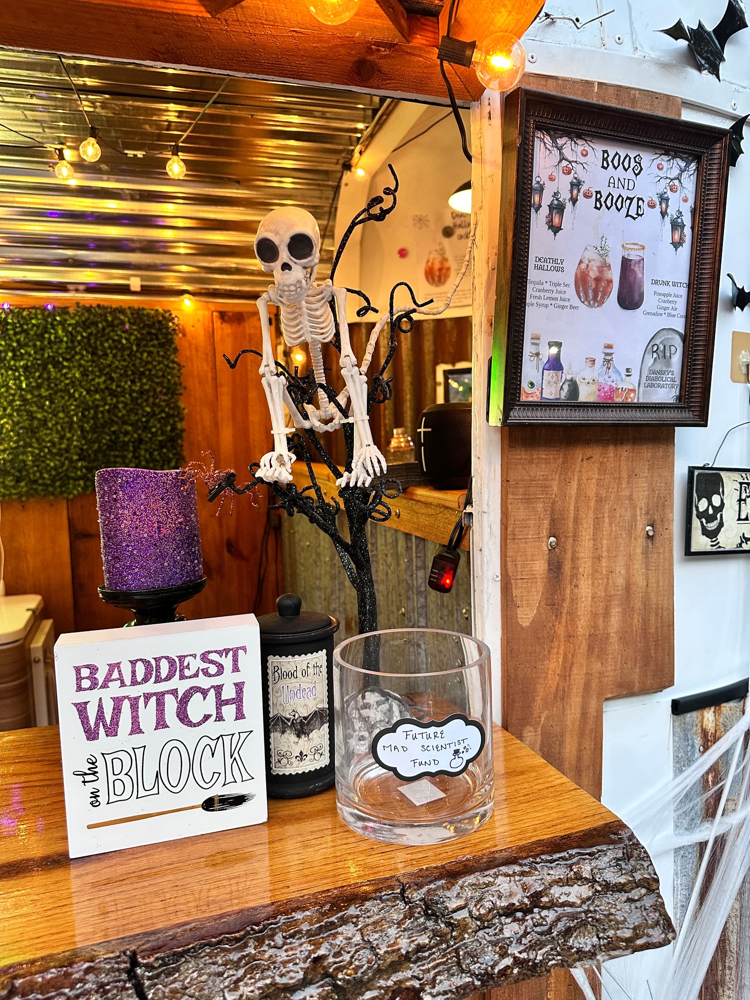 Halloween decorations inside The Hitching Post trailer - Boos and Booze cocktail menu, skeleton, Baddest Witch on the Block sign