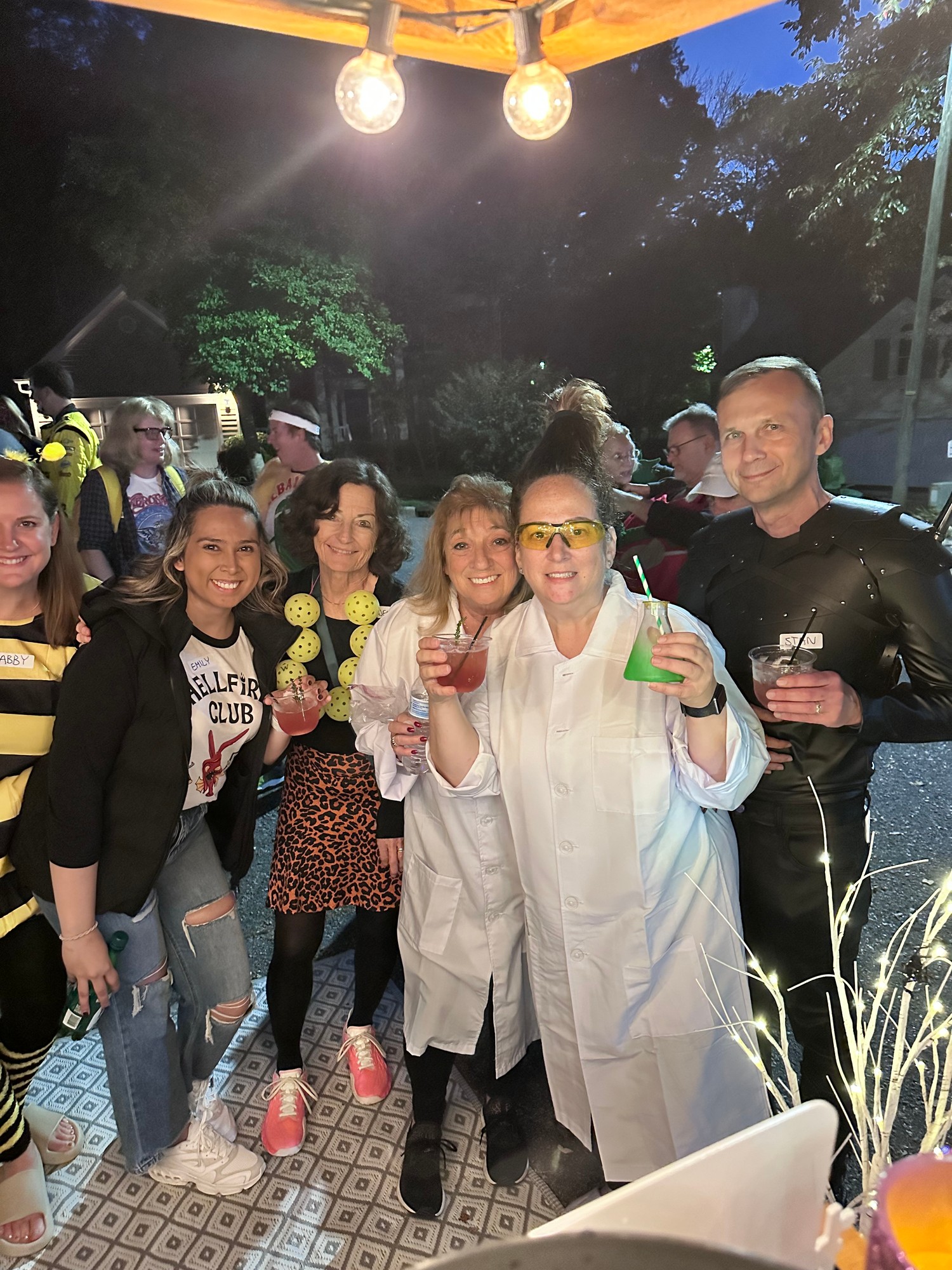 Group of costumed Halloween party guests holding cocktails with Lisa and Olivia from The Hitching Post