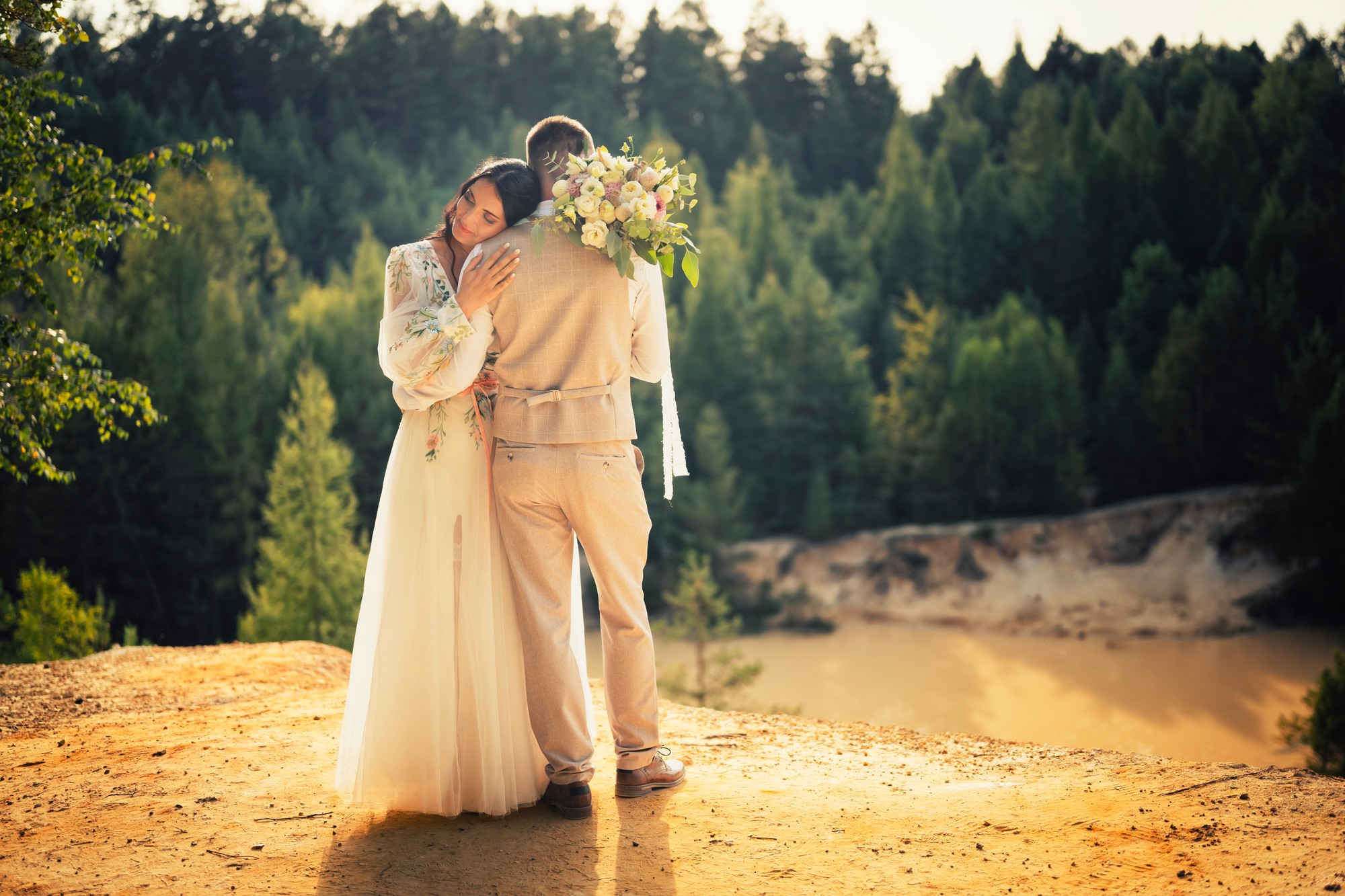 Novomanželé v objetí v přírodě