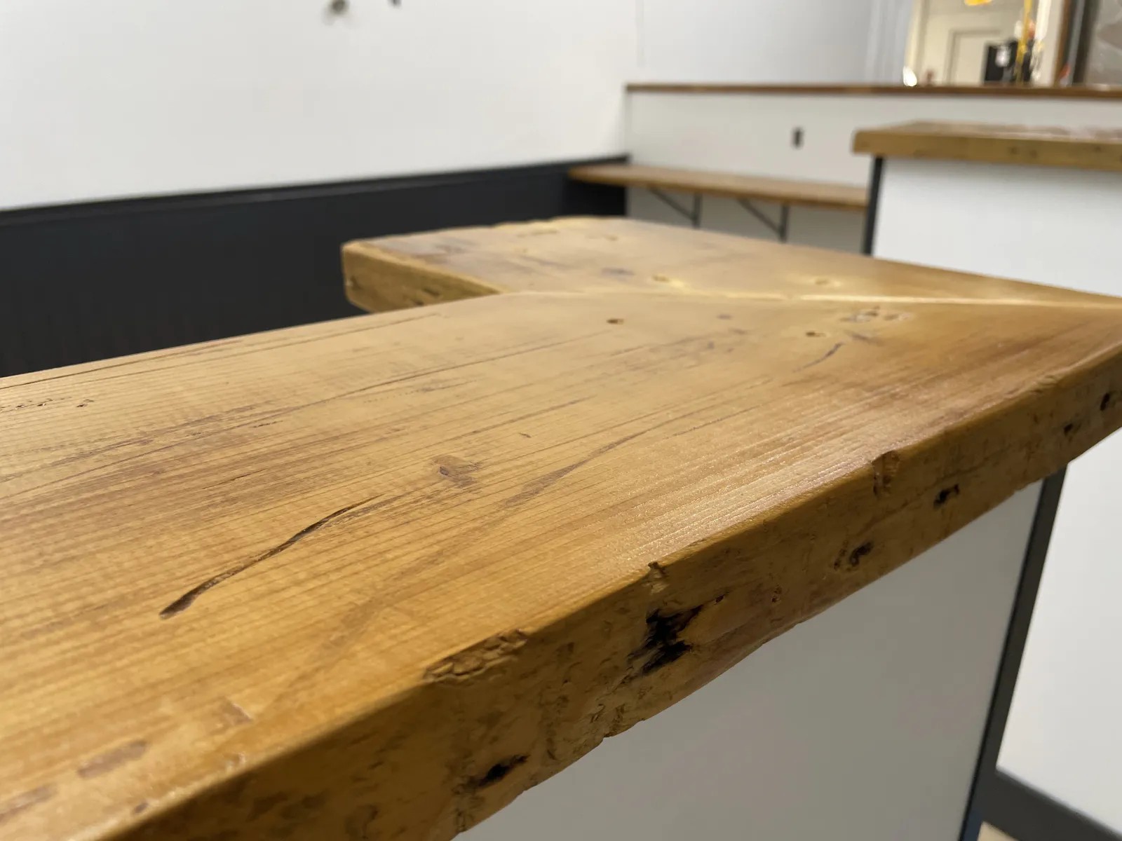 Finished wraparound custom wood bar in a black and white room