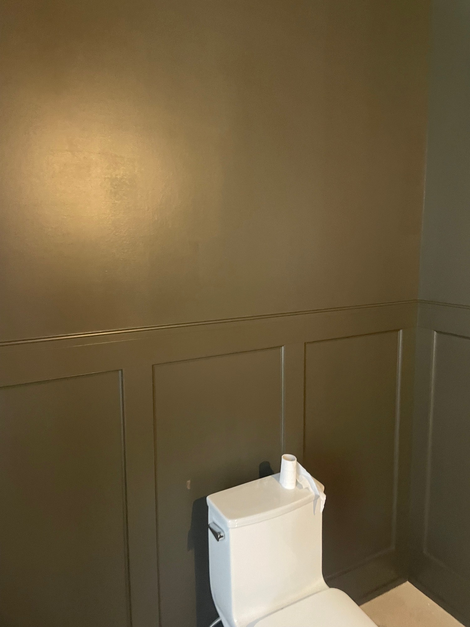 Paint roller applying white paint to a wall