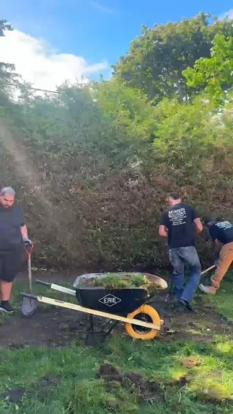Saunders Solutions crew clearing a job site with wheelbarrow and shovels