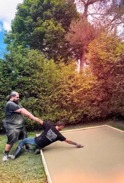Two-man Saunders Solutions team finishing a concrete slab together