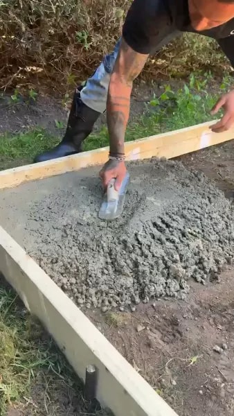 Fresh concrete being poured and spread into the form