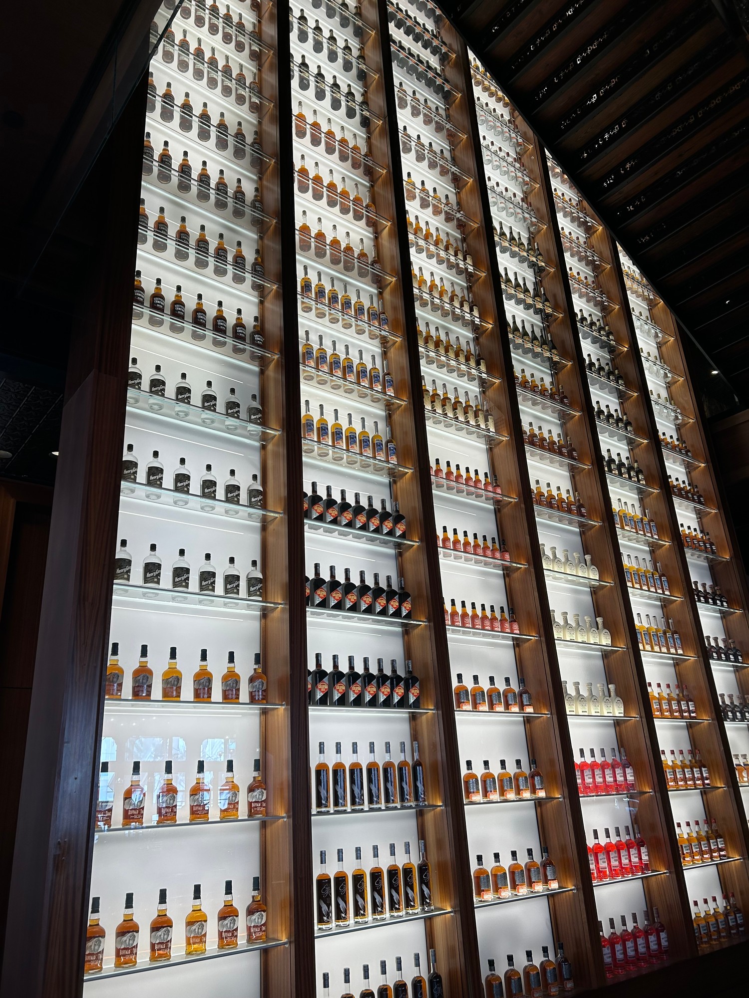 A wall of illuminated spirit bottles inside the Sazerac House