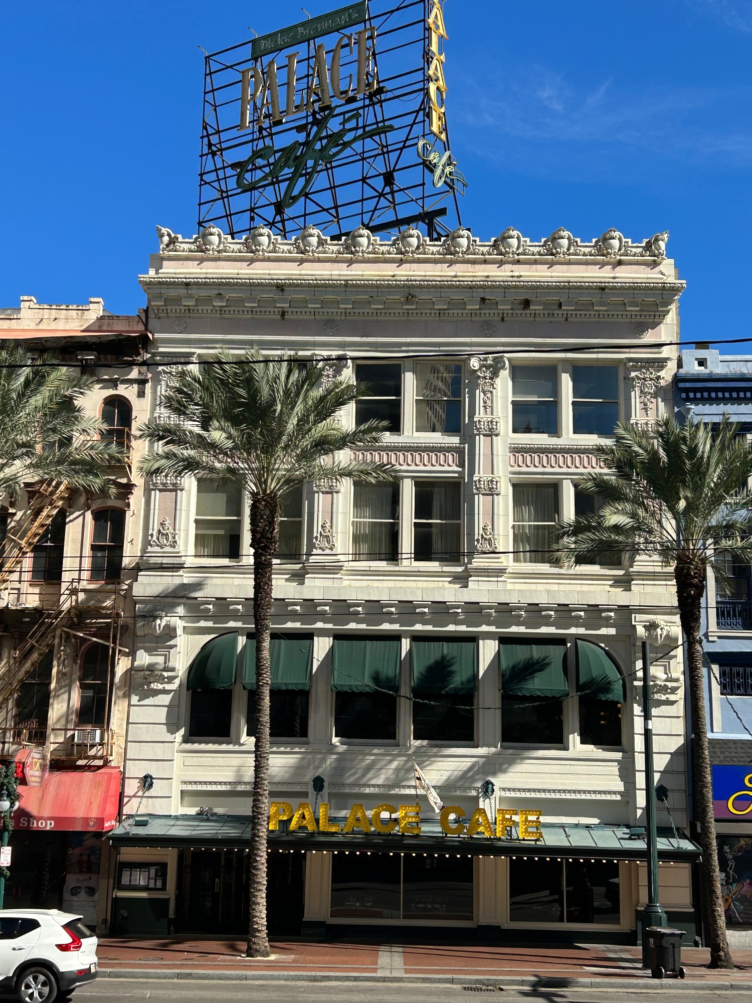The ornate Palace Cafe building on Canal Street, New Orleans, with palm trees in front