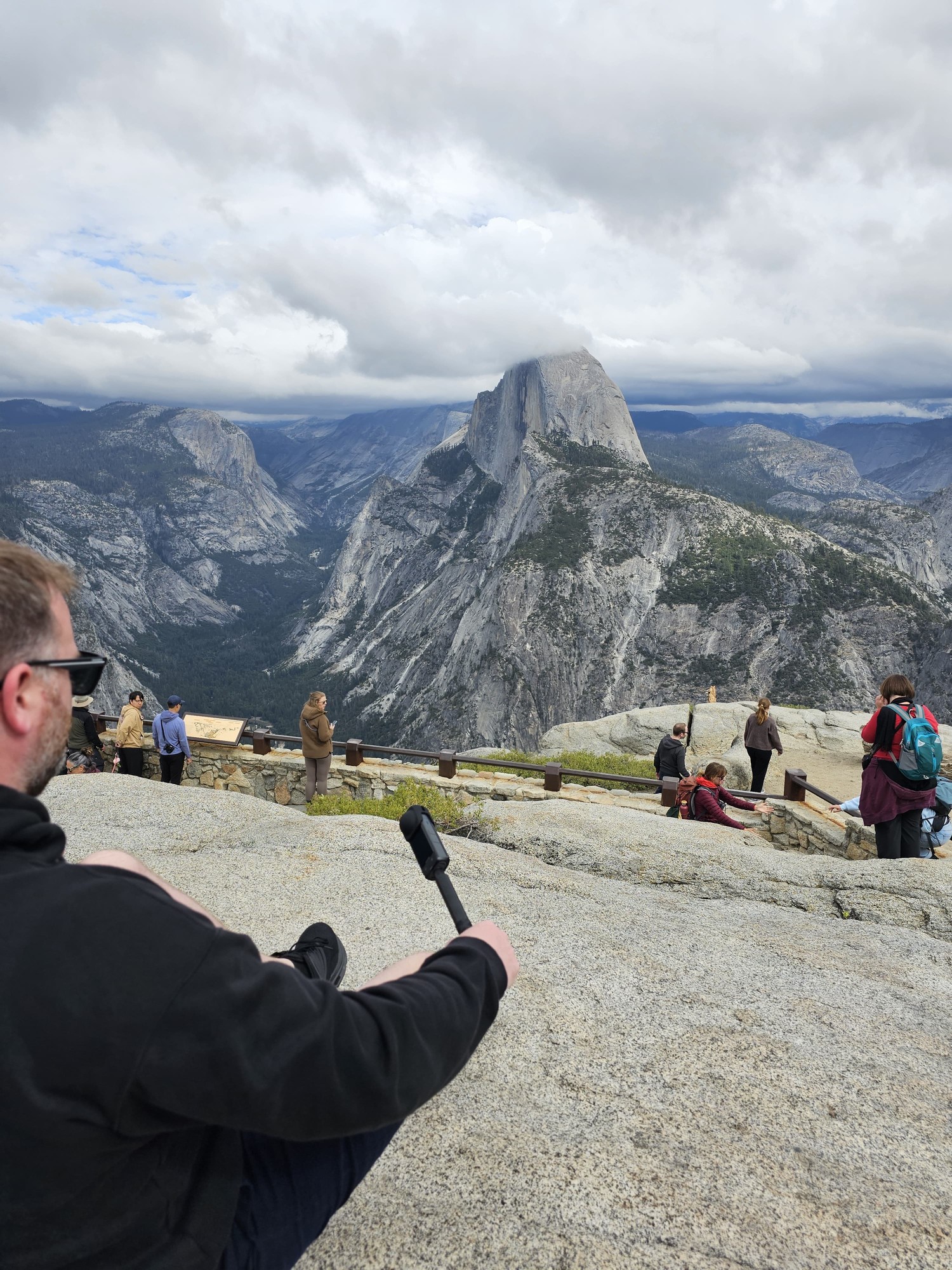 Me sitting on the granite at Glacier Point, watching Half Dome in Yosemite