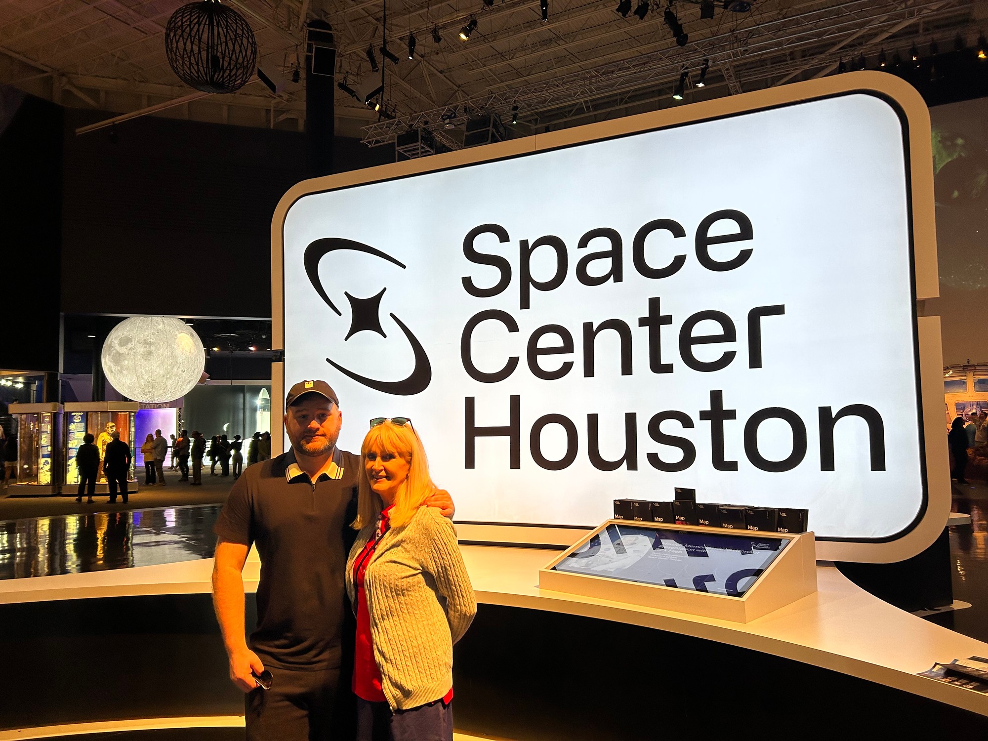 At the Space Center Houston entrance sign, with the moon exhibit behind