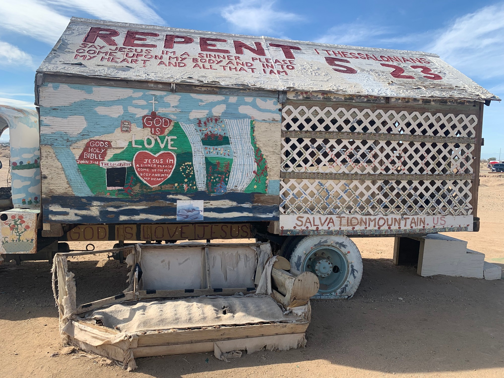 A Salvation Mountain wagon painted with the word REPENT and verses