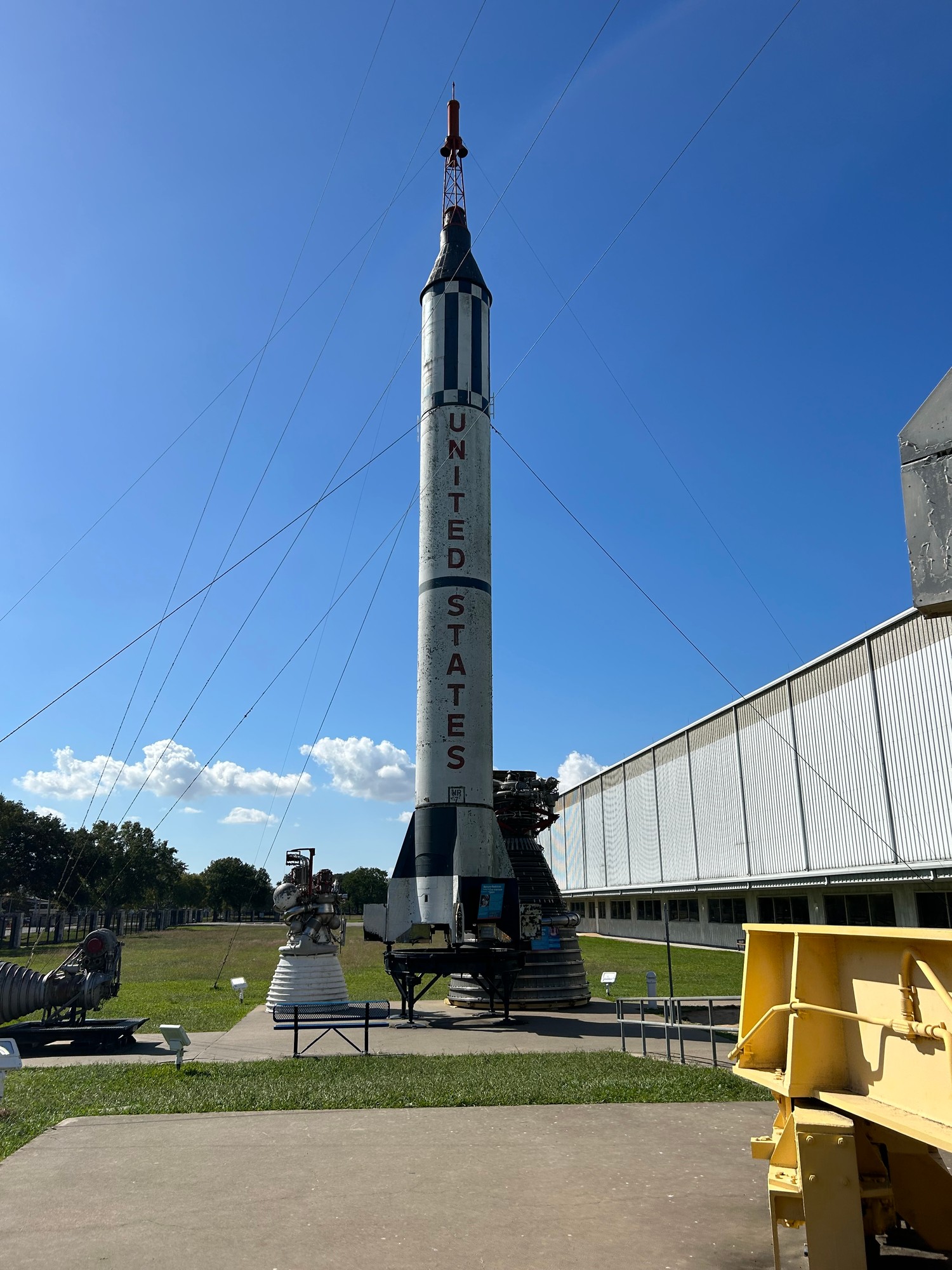 A Mercury-Redstone rocket standing in Rocket Park at Space Center Houston, with rocket engines displayed around it