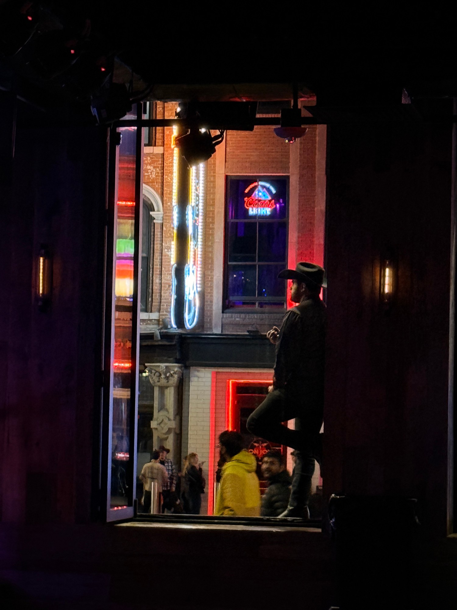 A night out on Broadway in Nashville, with neon signs and a cowboy hat in the crowd