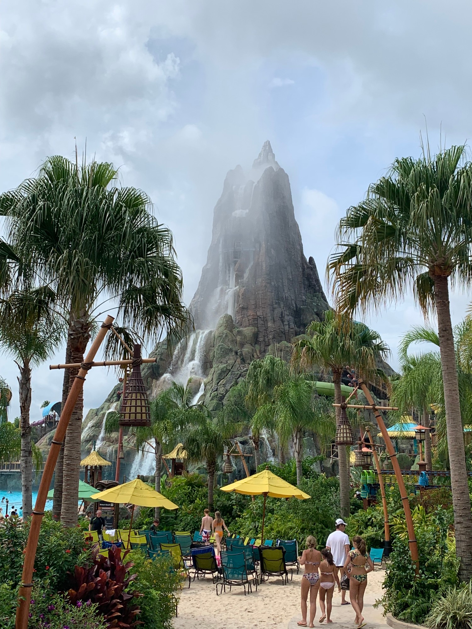 The volcano at Volcano Bay water park in Orlando, ringed by palm trees and loungers