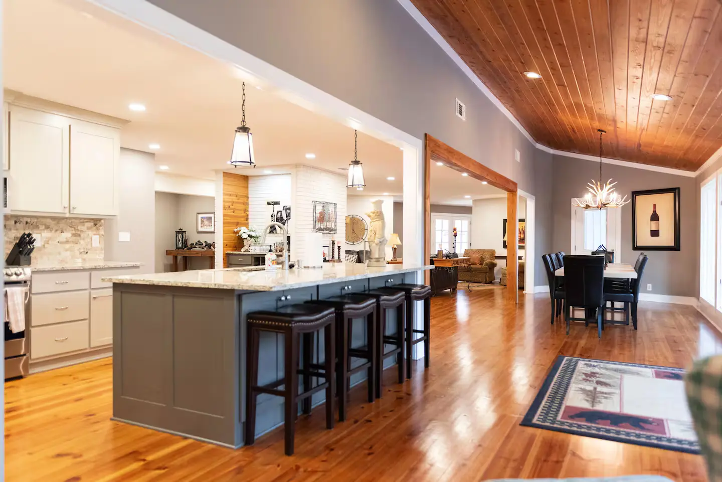 Interior photo of the living area with stone fireplace and forest view windows