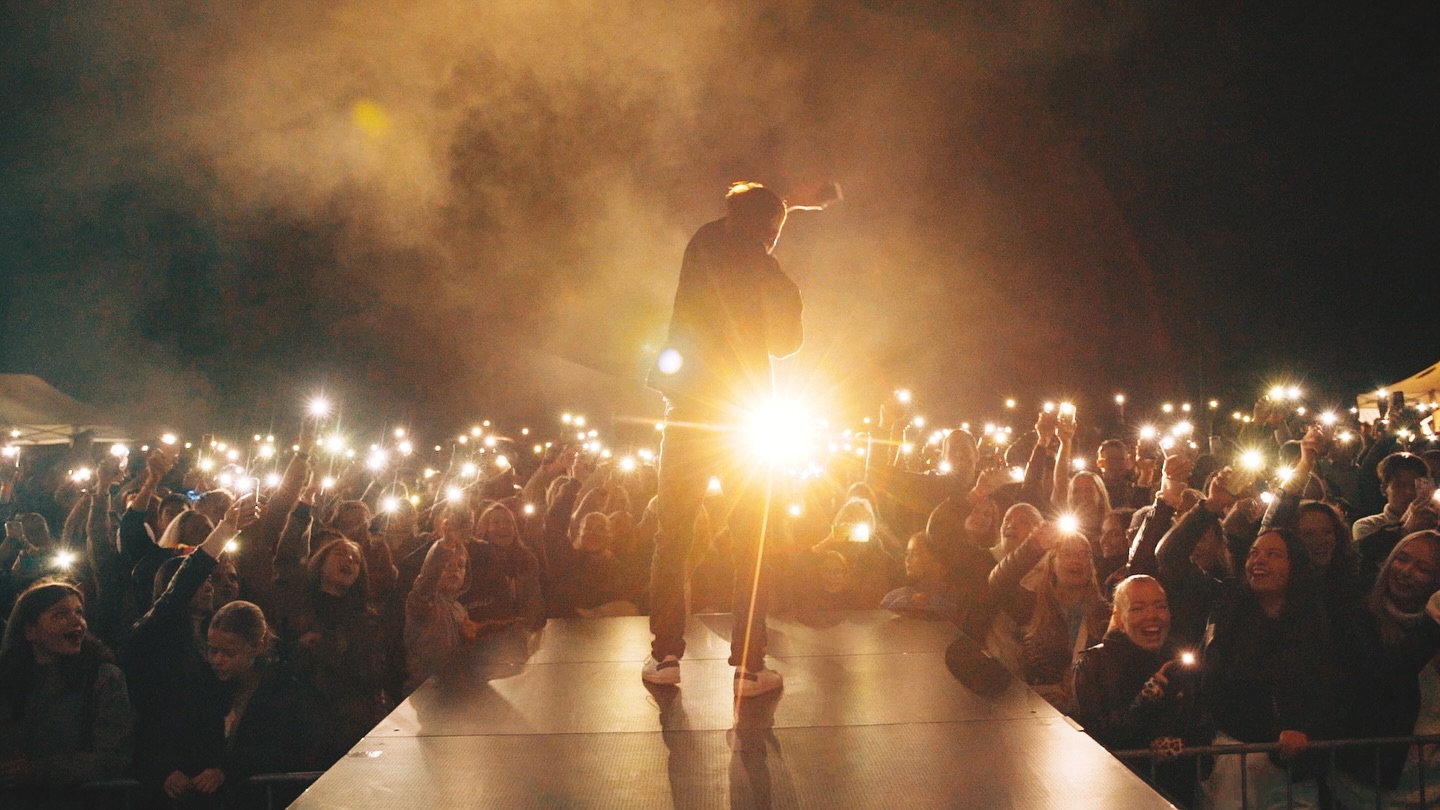 Frontman na pódiu s mobilními světly publika