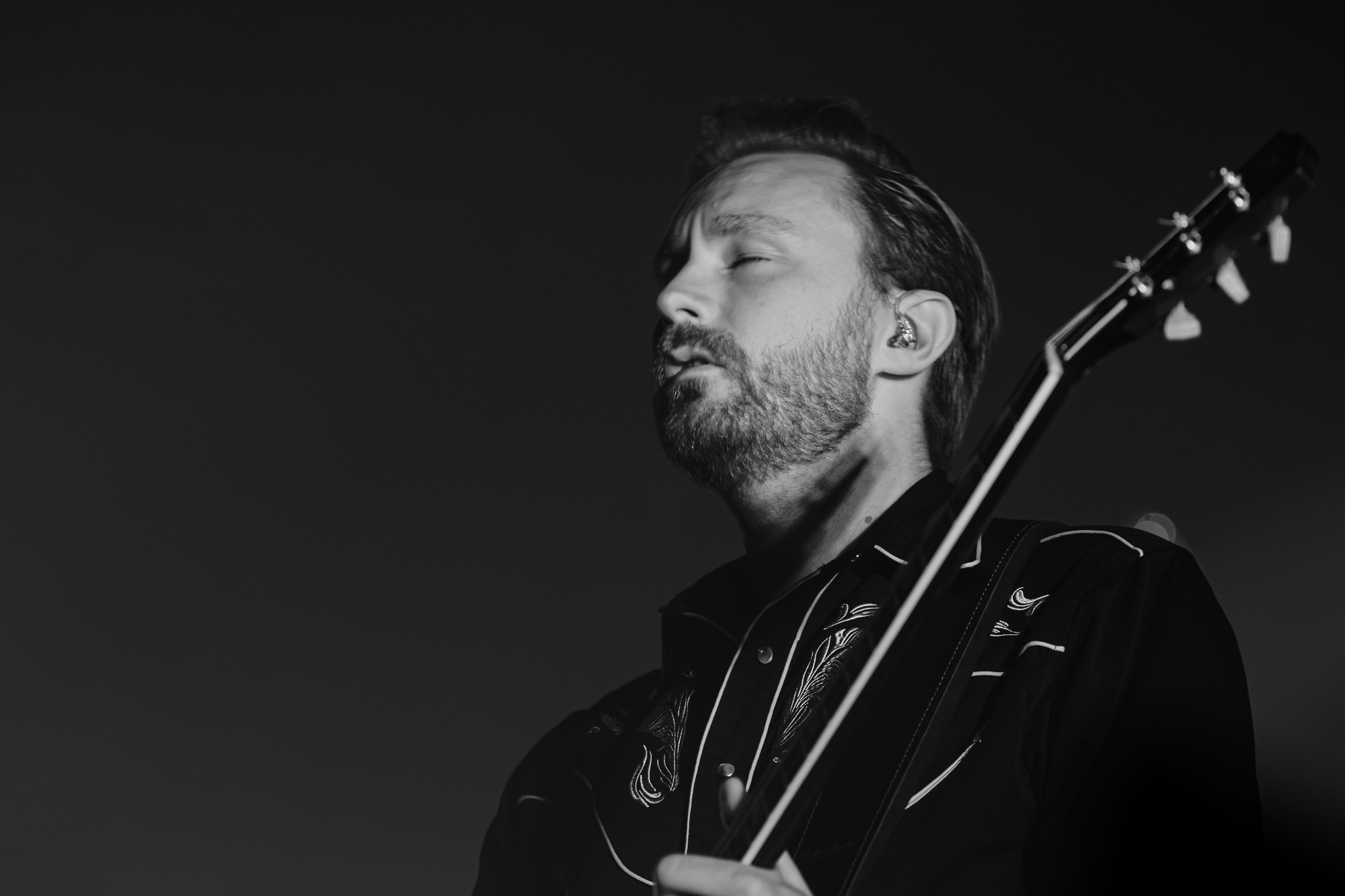 Musiker med guitar i sort-hvid på scenen