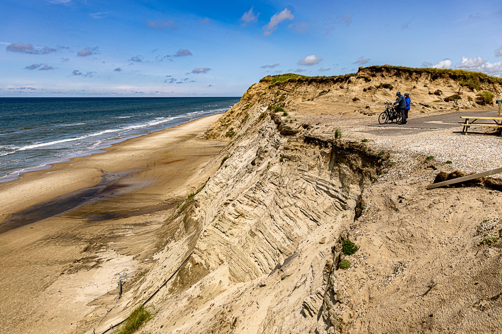 Kystklint og strand under blå himmel