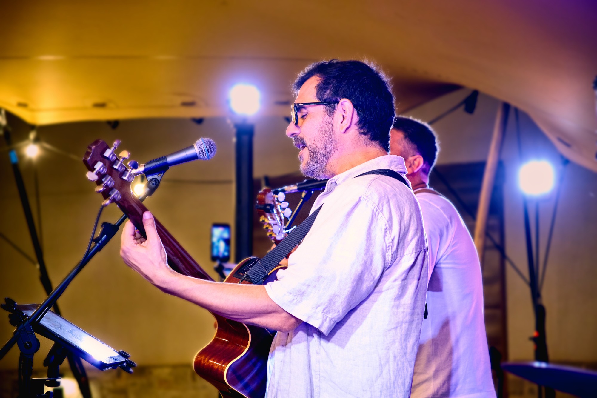 Joan Tena cantando con la guitarra en una actuación