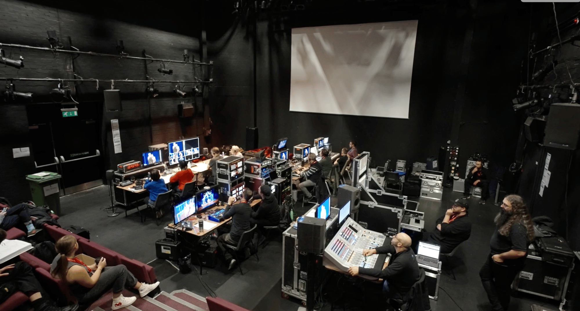 The production gallery mid-event: camera monitors, vision mixing and the production crew at work in a dark studio