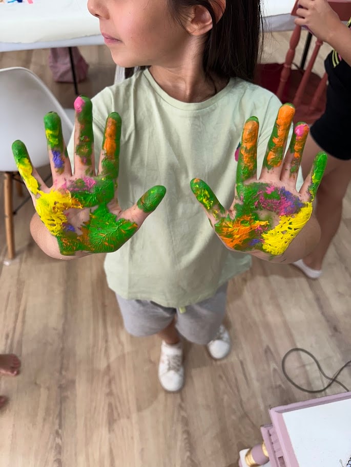 Criança a mostrar a sua obra de arte criada no atelier MitoArte