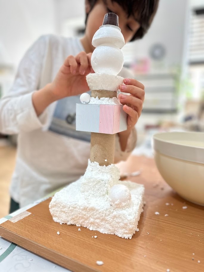 Criança em processo criativo no atelier MitoArte — construção e imaginação