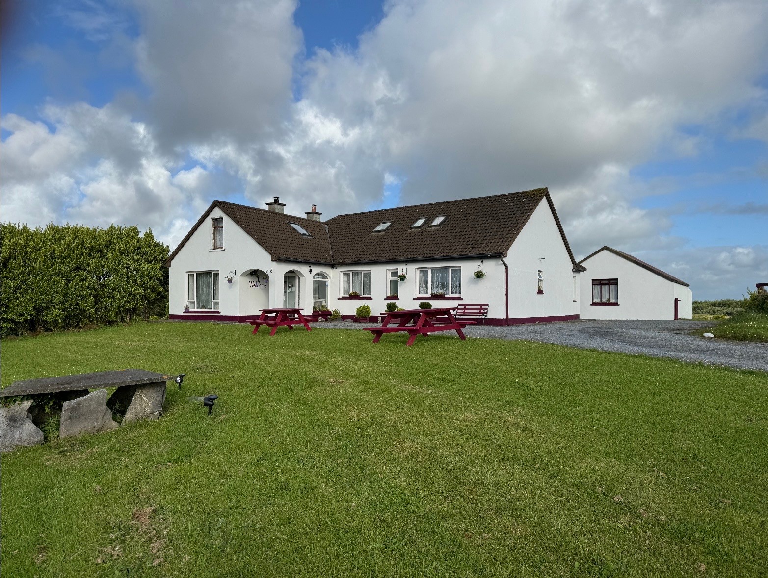 Puffin B&B exterior with green lawn and red picnic tables