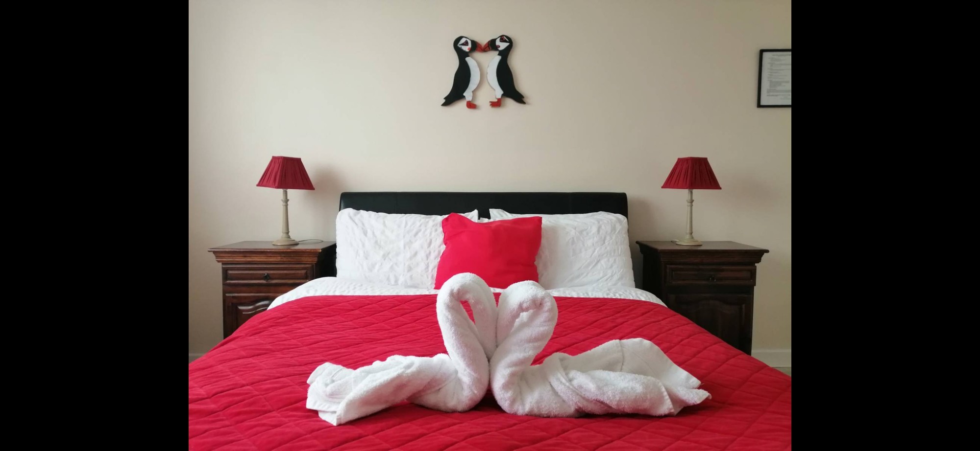 Puffin B&B double bedroom with red bedding and towel swans