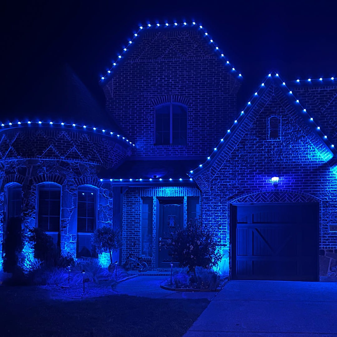 Stunning permanent RGB holiday lighting on home exterior with blue lights