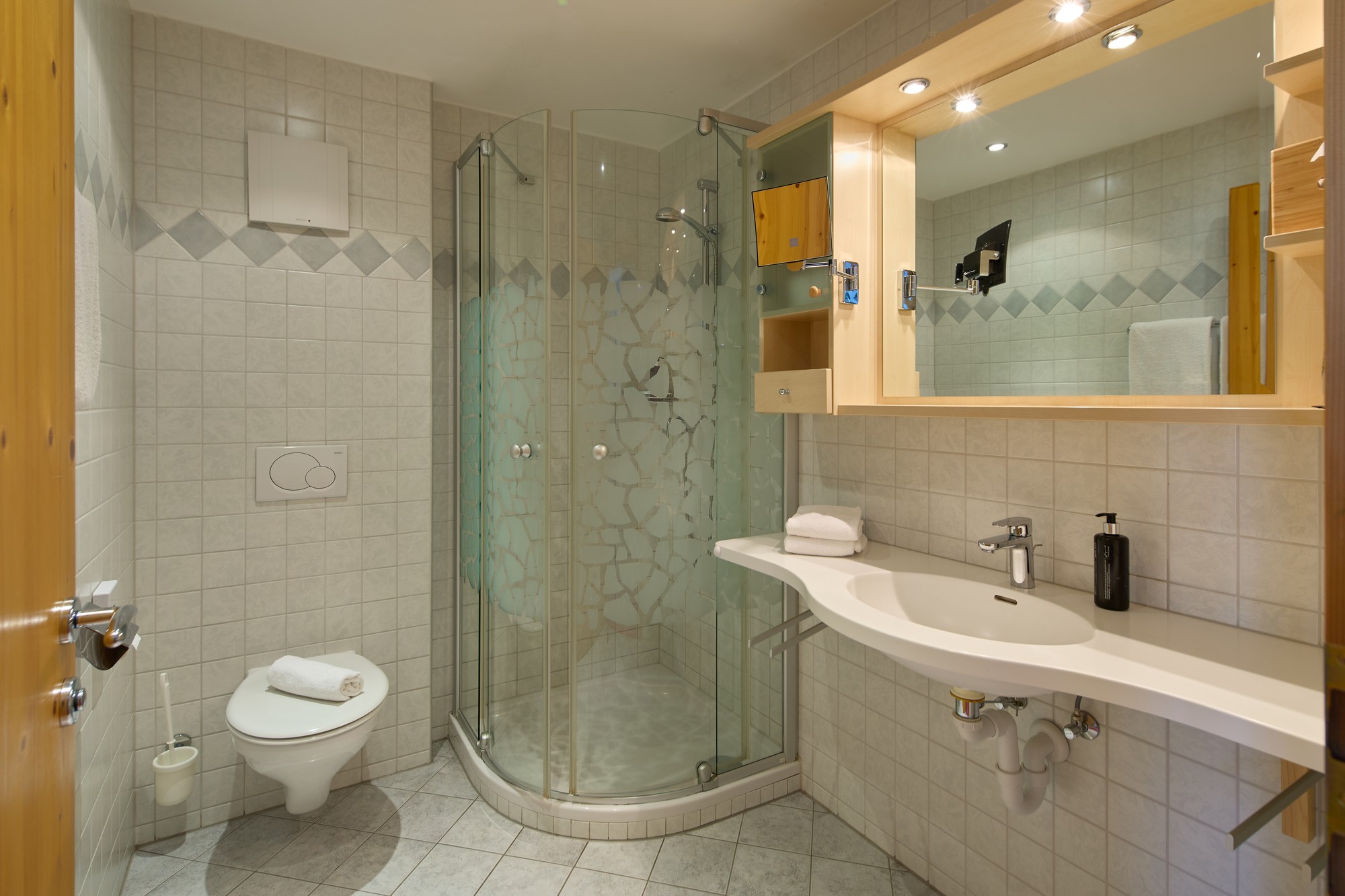 Badezimmer mit Dusche, WC und Waschtisch im Doppelzimmer Plus