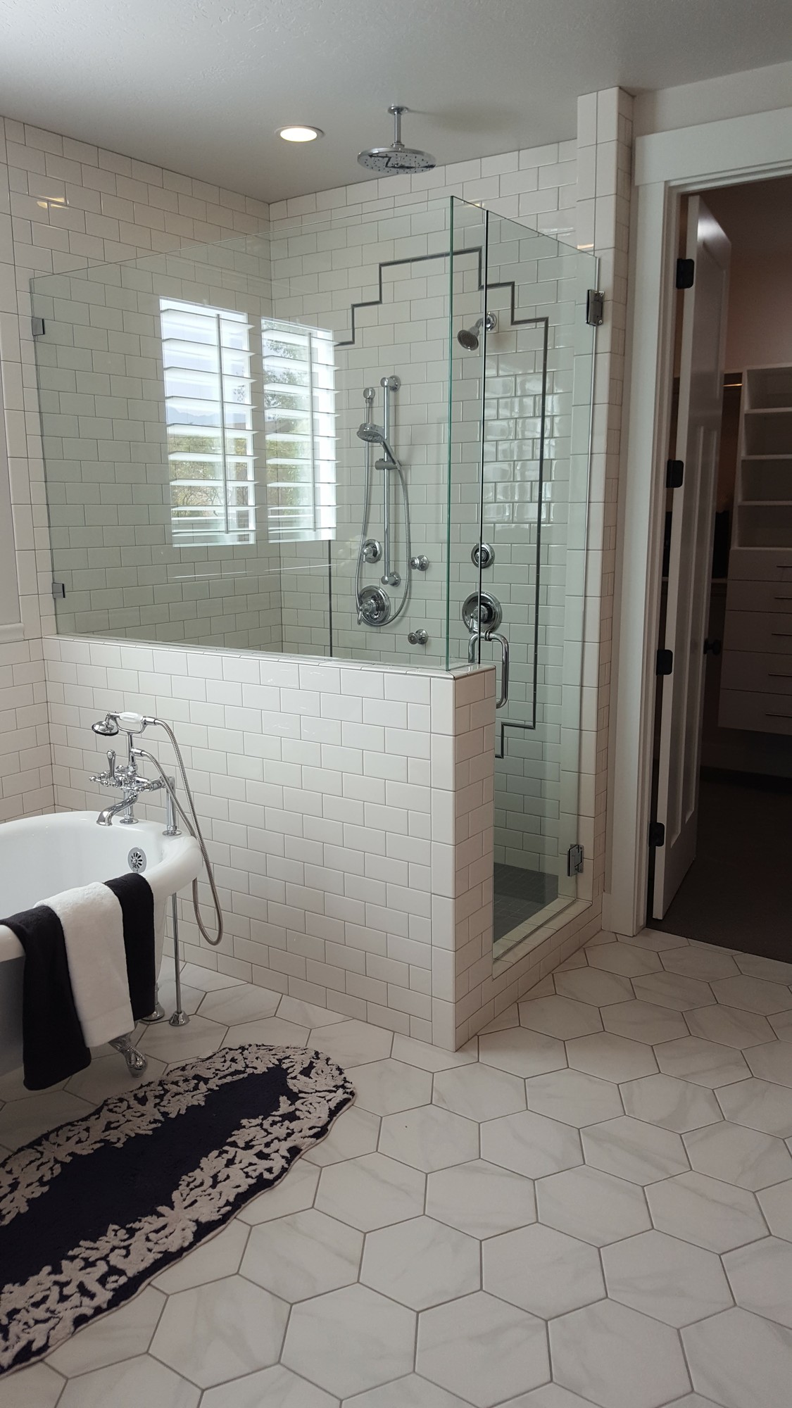 Master bathroom — clawfoot tub, subway tile walls, glass shower, hexagon floor tile