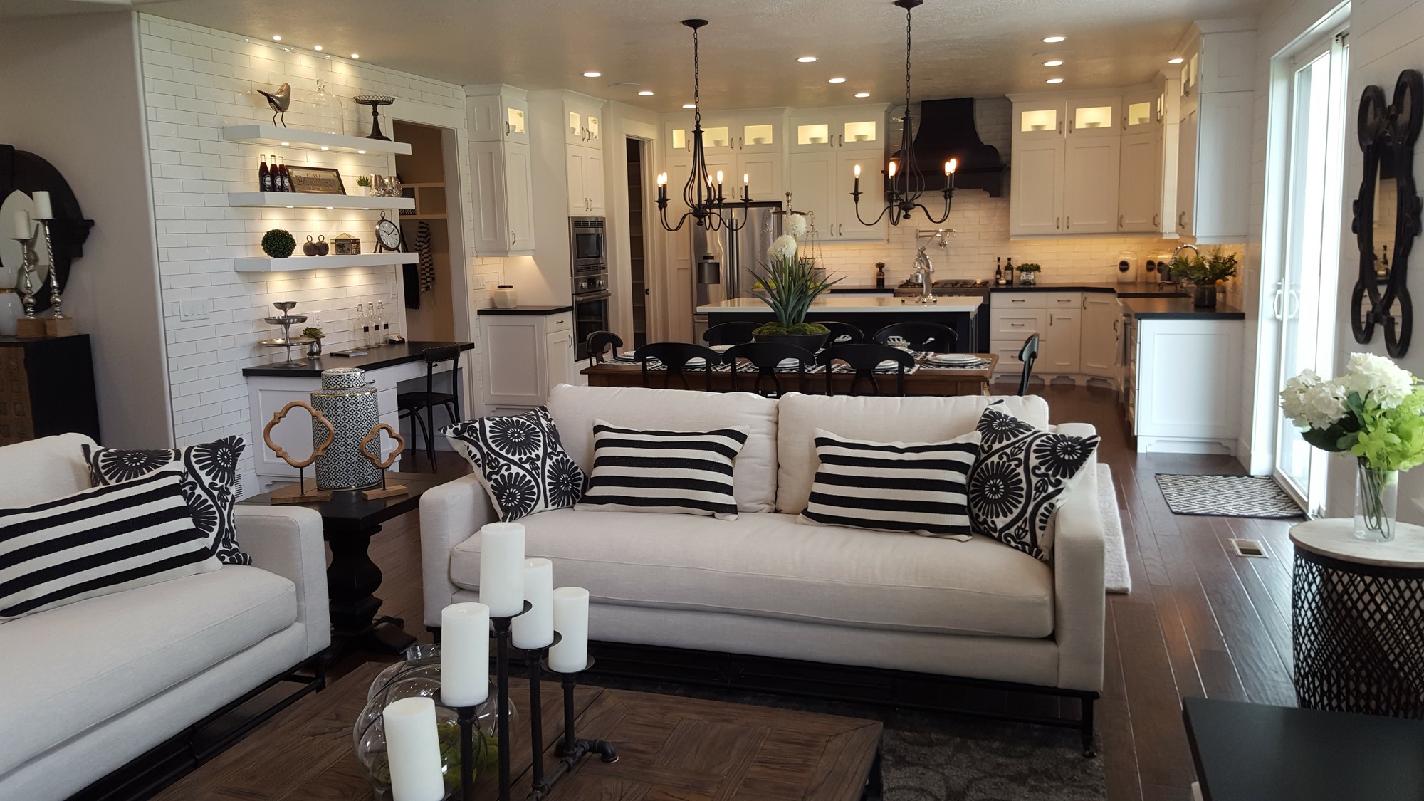 Parade of Homes open-plan living room and kitchen — white shaker cabinets, hardwood floors