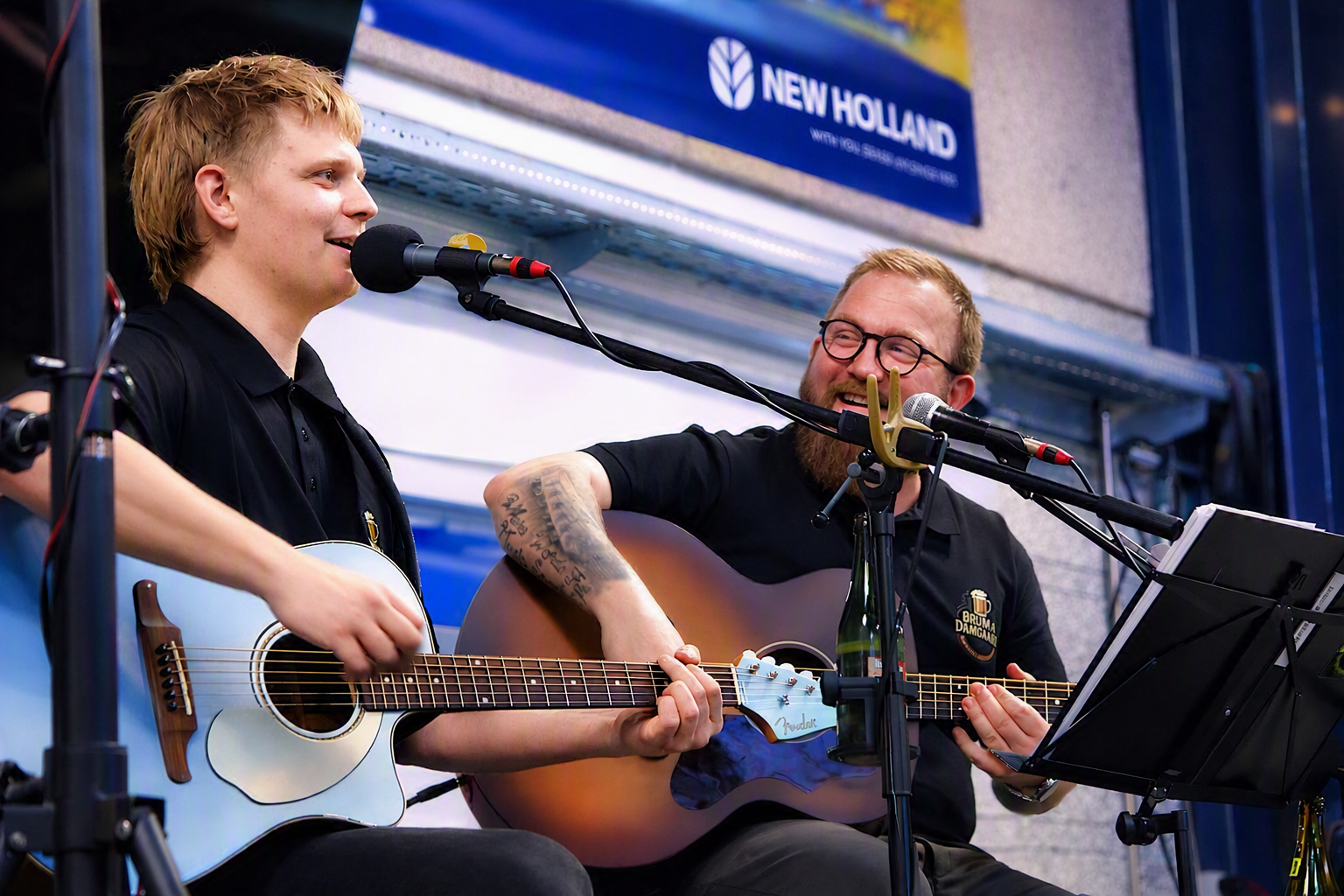 Musiker med guitar og mikrofon foran et feststemt publikum