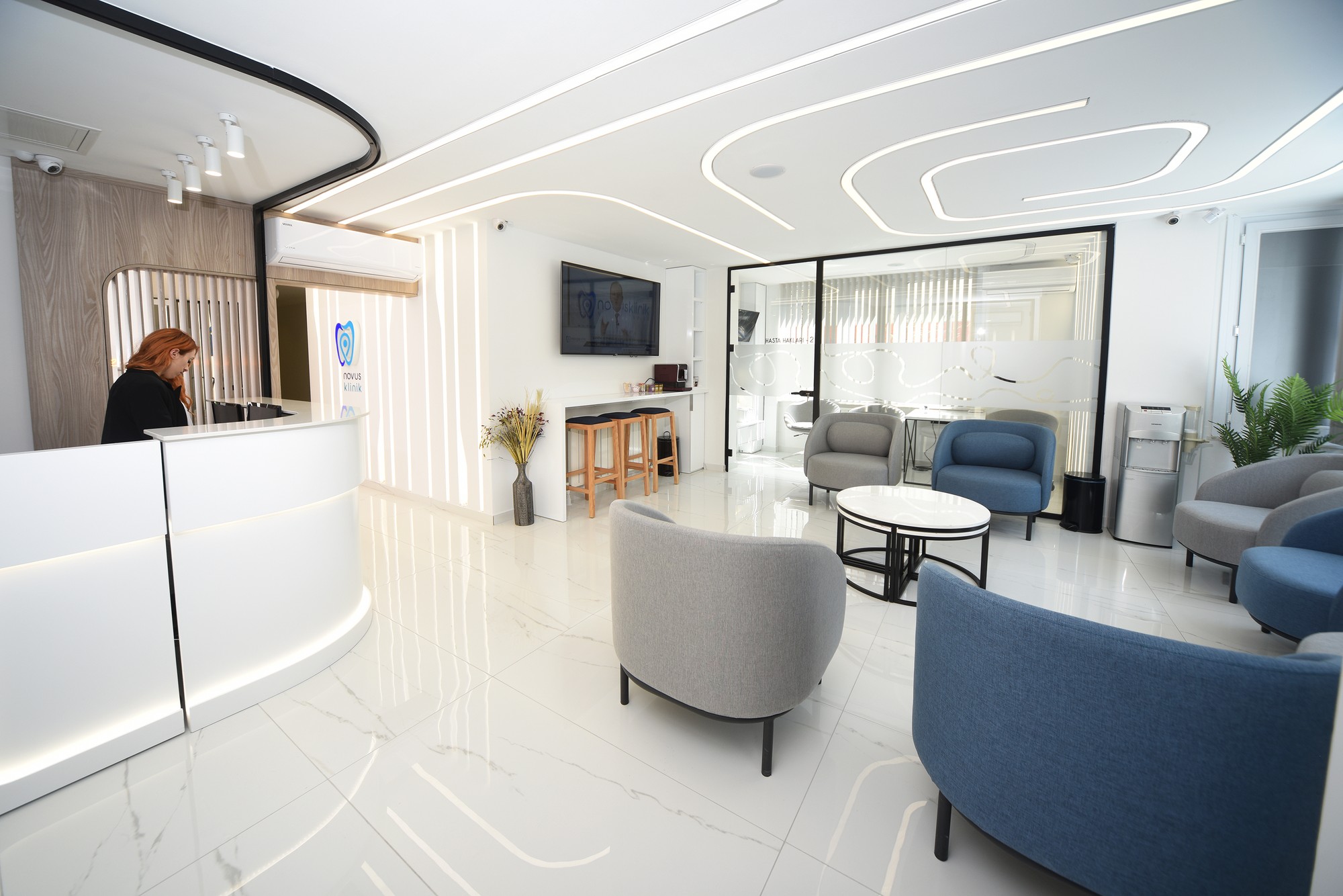 Recepce naší kliniky Kadıköy, bílý pult, modré křesla