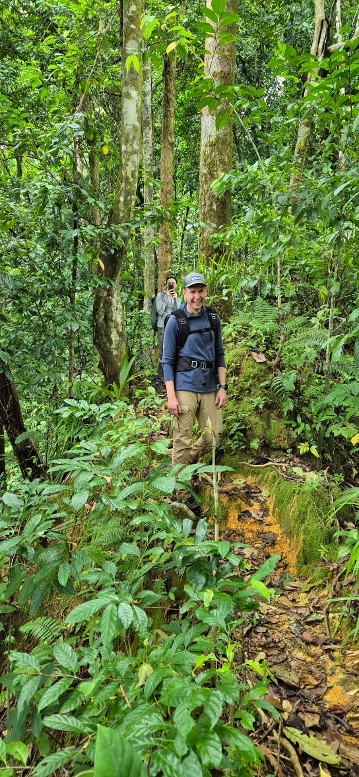 Caminhante a percorrer a floresta primária densa na trilha para o Pico Cão Grande, São Tomé