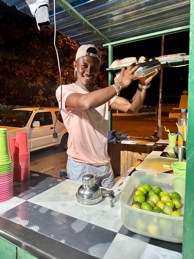 Street vendor preparing fresh juice in São Tomé, exemplifying daily leve leve rhythms