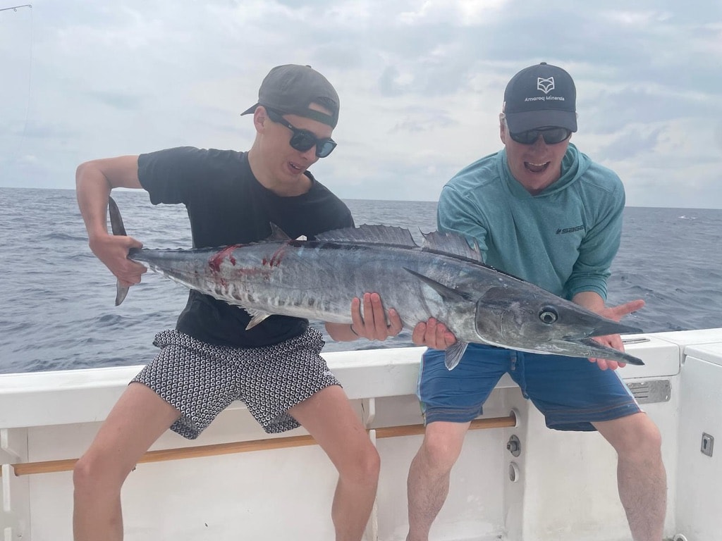 Dois pescadores a segurar um wahoo grande apanhado em alto mar ao largo de São Tomé
