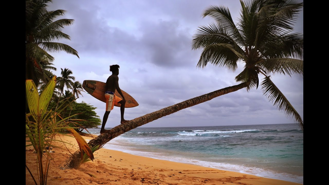 Local surfer riding a wave in São Tomé