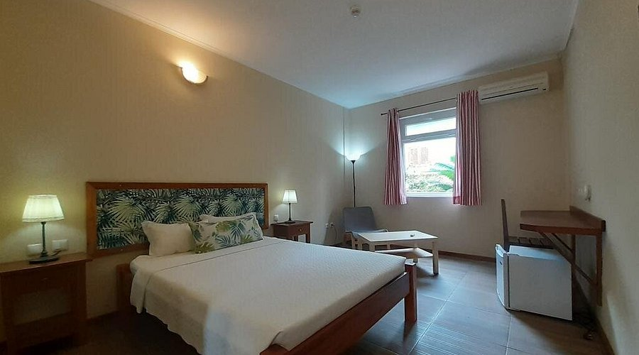 Double room with tropical print headboard at Emoyeni Gardens Boutique Hotel in São Tomé city