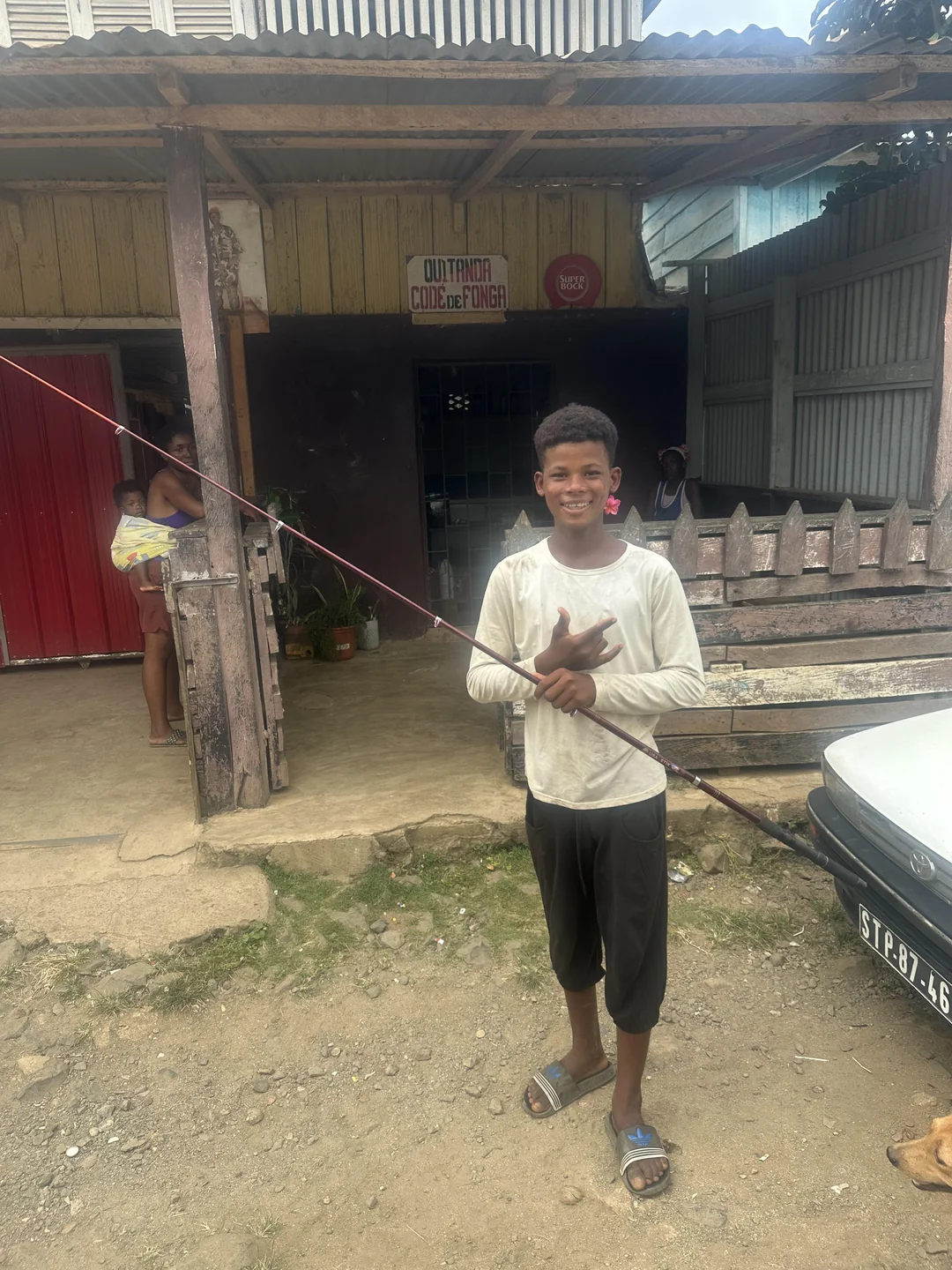 Um adolescente à porta de uma loja local em São Tomé, a sorrir