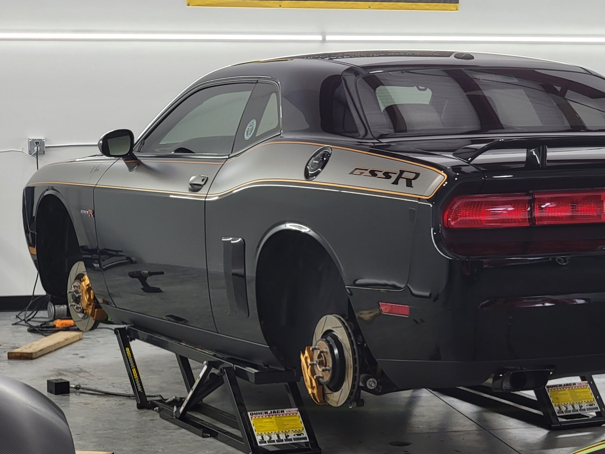 Vehicle on quick jacks with wheels off during a full detail at Revival Autoworks