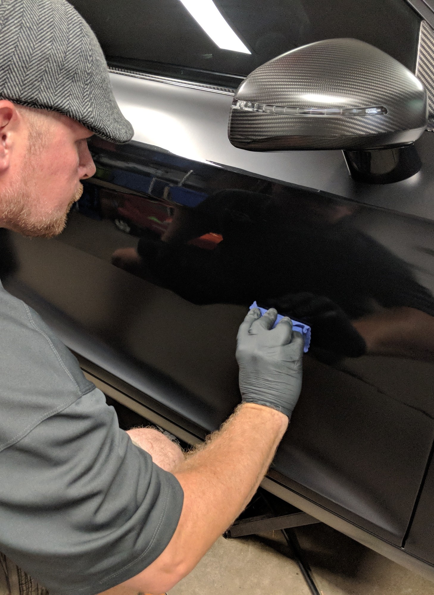 Ceramic coating being applied to a black vehicle at the Revival Autoworks studio