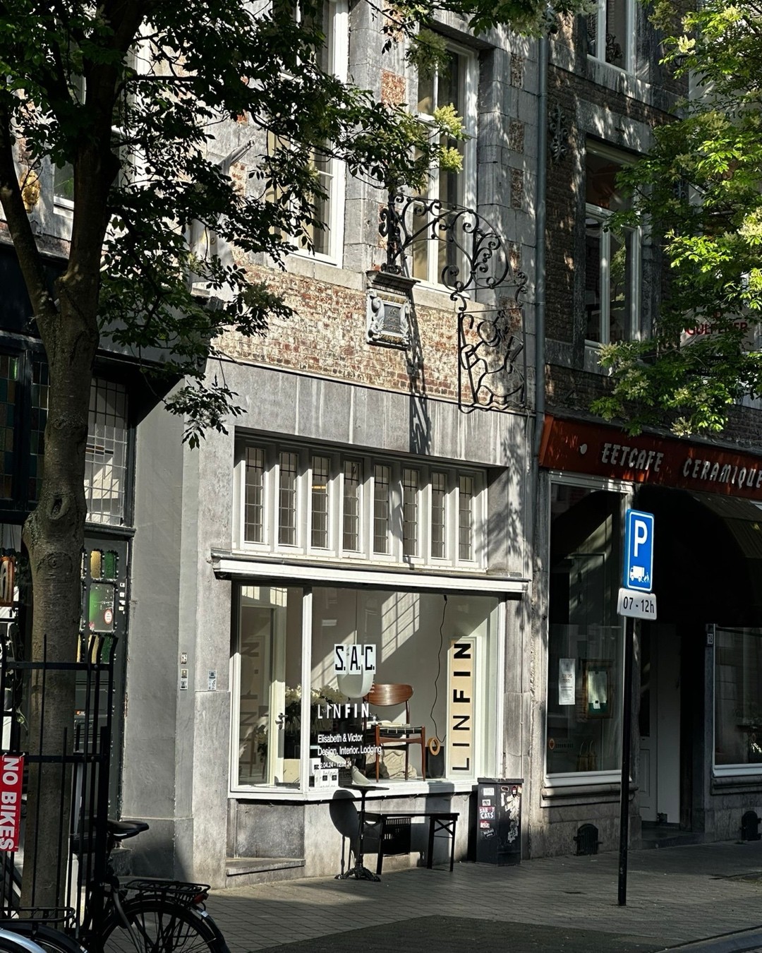 The LINFIN boutique facade at Rechtstraat in Maastricht, with trees casting shadows over the stone exterior