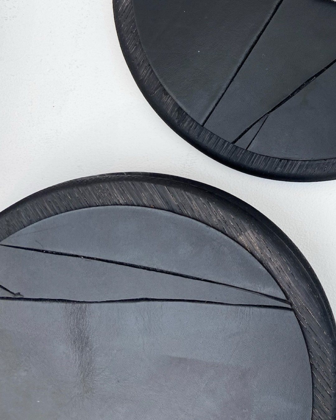 Black oak LINFIN underplate paired with a stone dish and white linen napkin