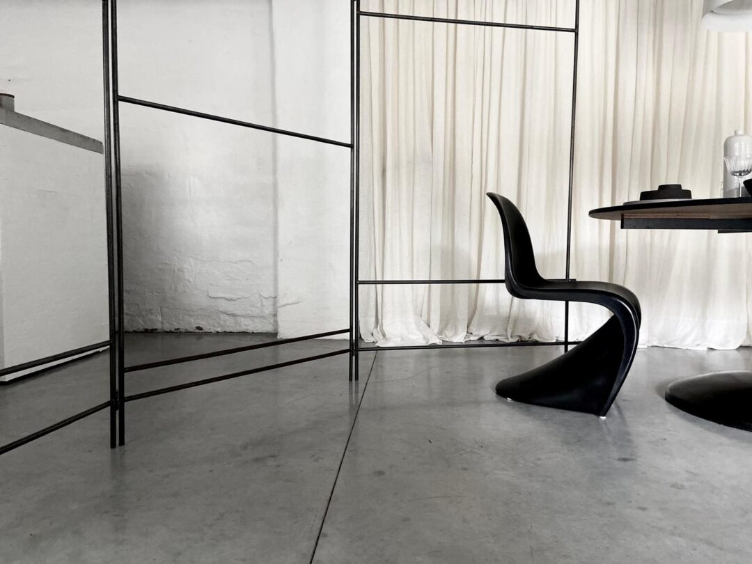 Two weathered concrete cube plinths on a natural woven rug inside the Beauty with Less store